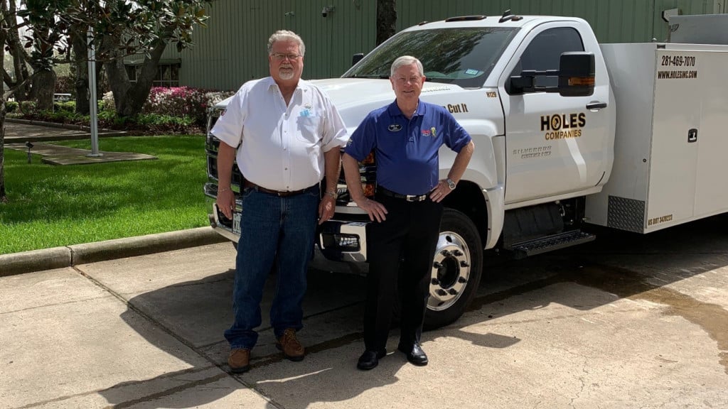 holes inc owners standing by knapheide saw truck