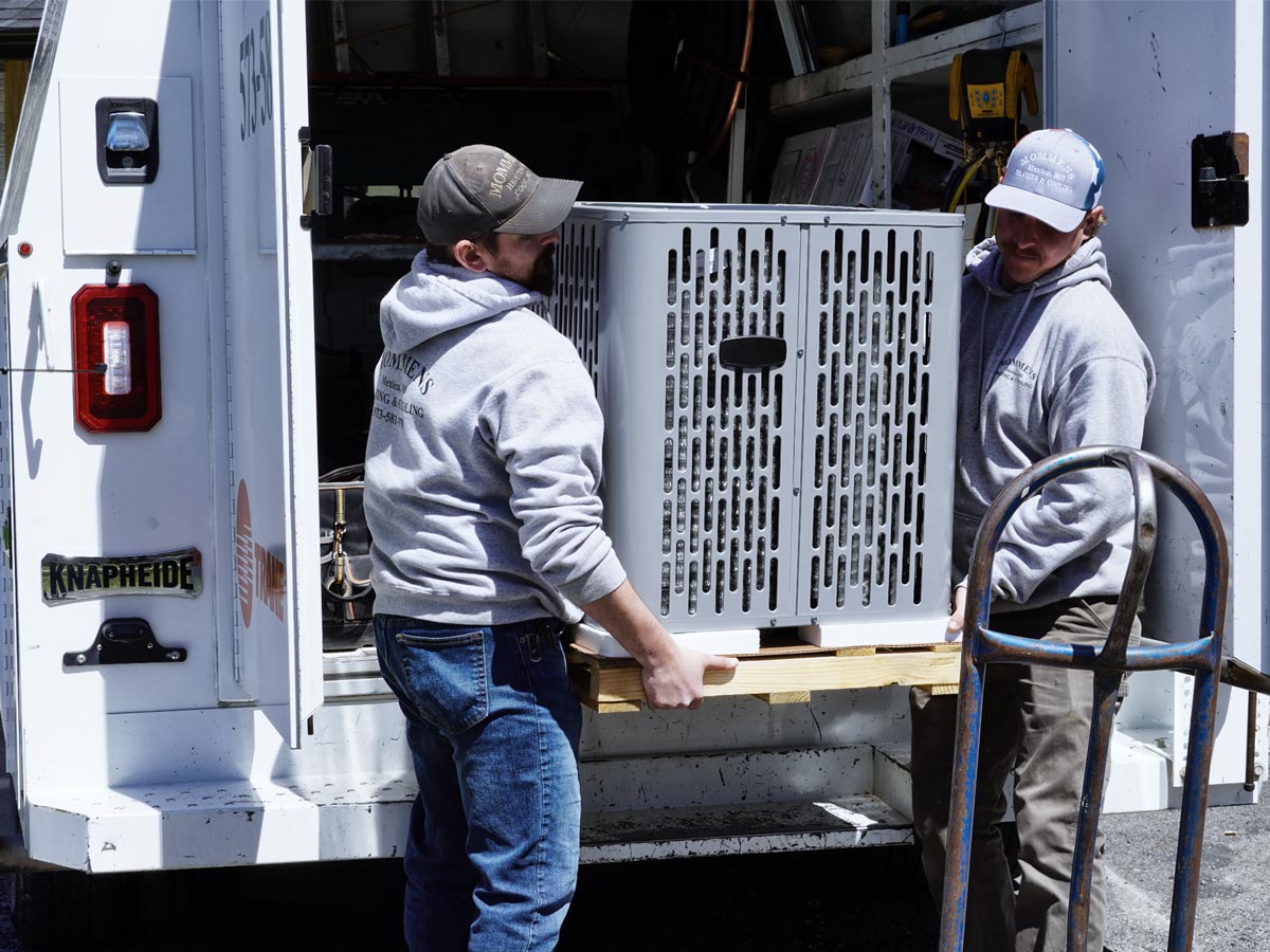 Mommens Heating And Cooling Field Techs Unloading Central Air Unit From Kuv Van Cargo Area Treated